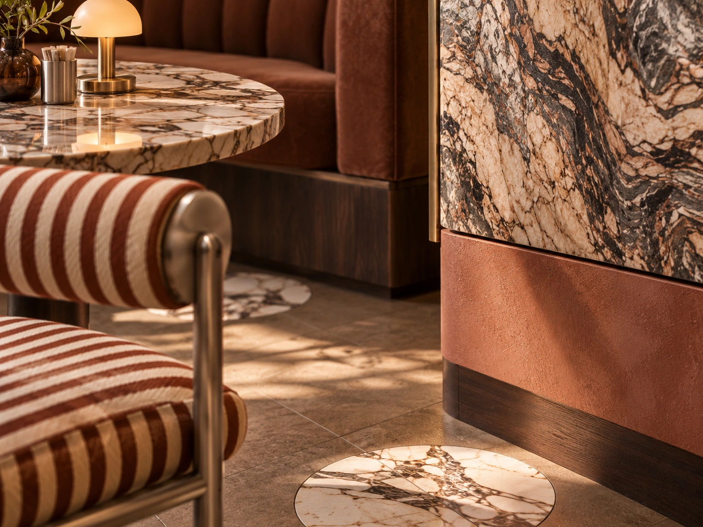 MERA Café & Bakery — detail of a striped metal-framed chair, a marble table and the veined stone counter front
