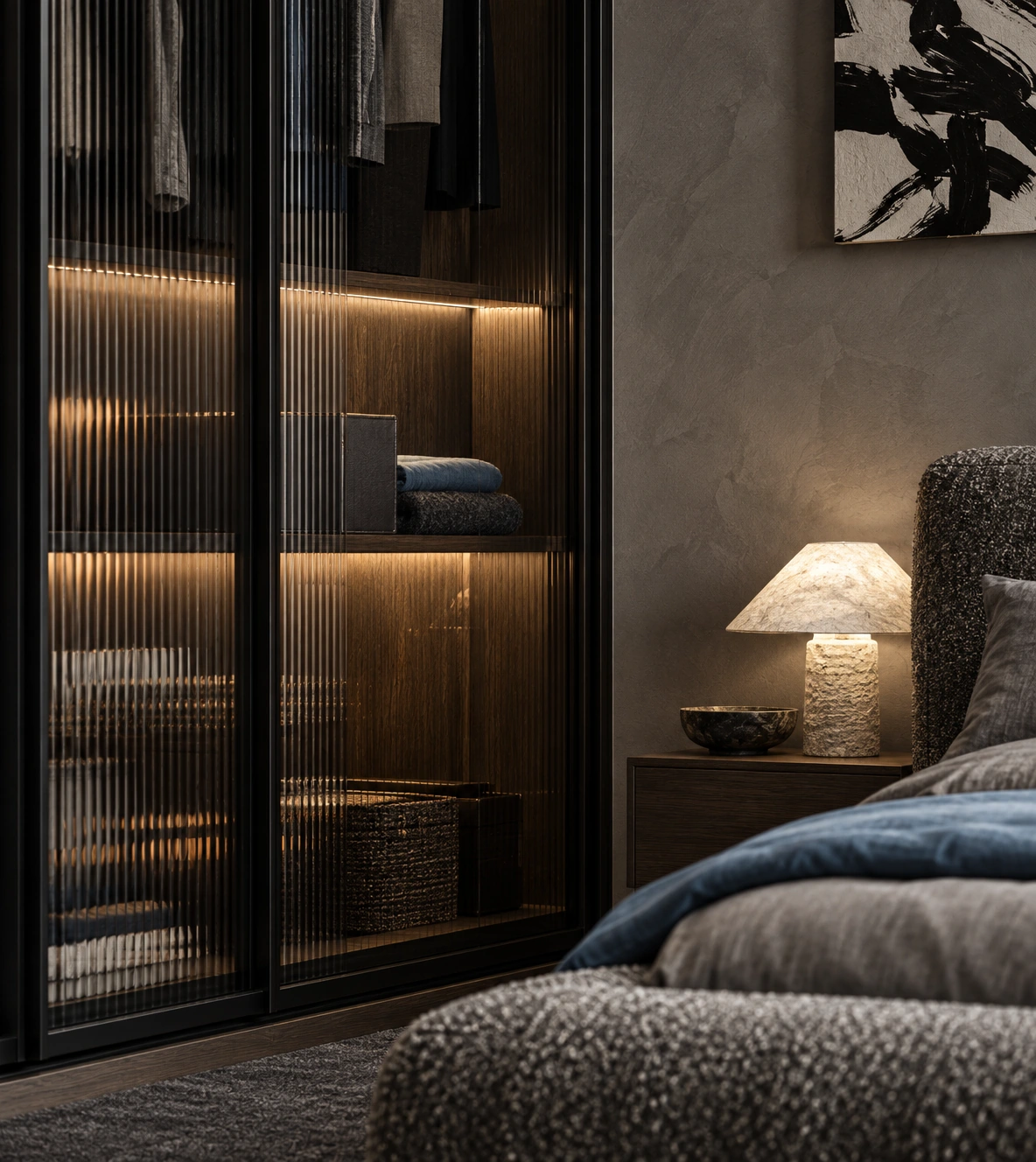 Nocturne — detail of a ribbed-glass wardrobe with warm lighting and a bouclé bedhead